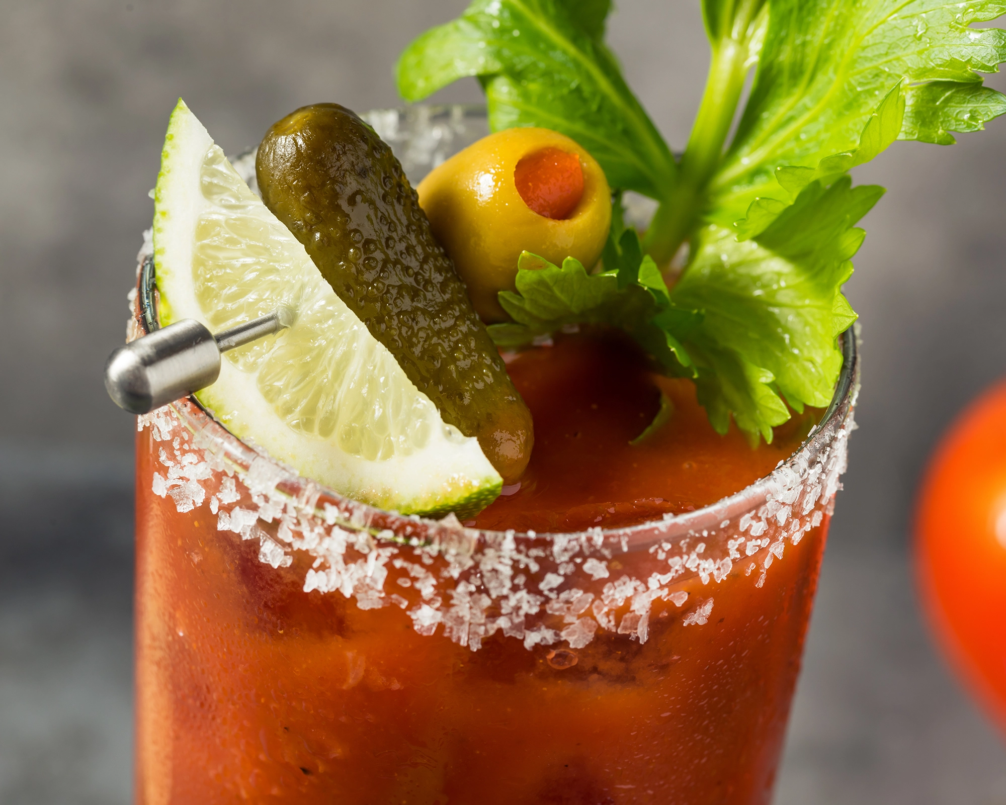 Bloody Mary with salted rim and celery, olive, pickle, and lime